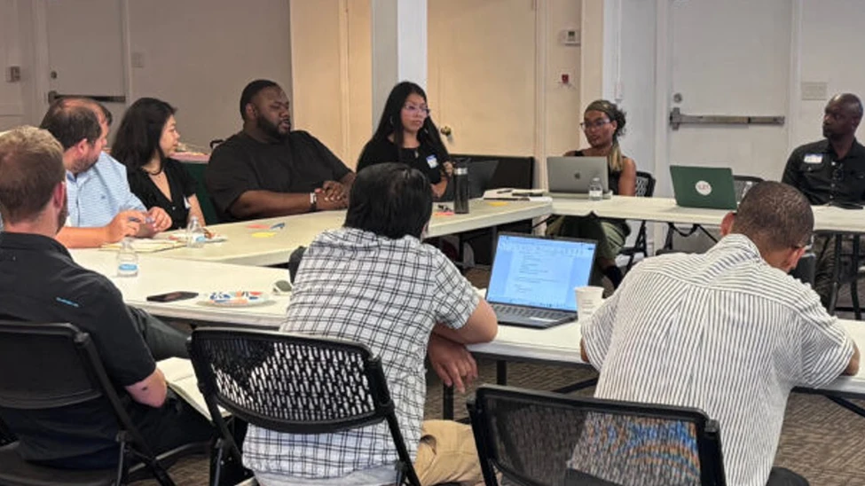 Attendees gather around tables at a United We Prepare workshop