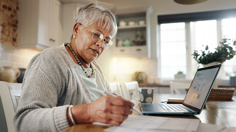Woman looking at computer and papers