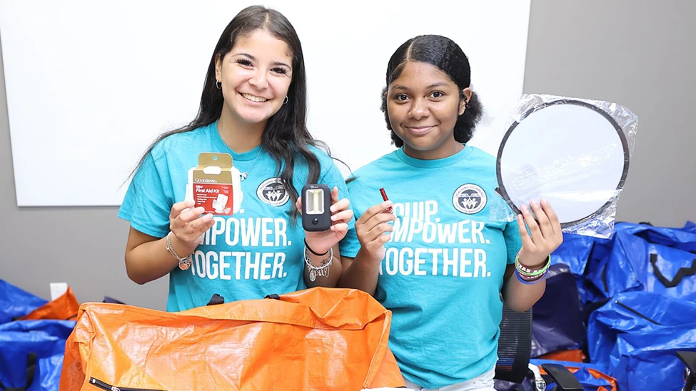 Two people holding up preparedness items at a workshop