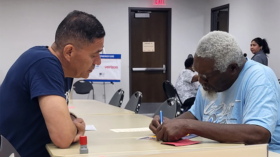 Two men filling out forms at a preparedness workshop in Houston