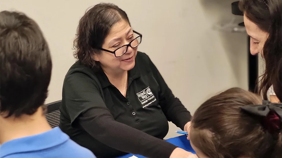 A volunteer helps attendees at a United We Prepare workshop in Houston