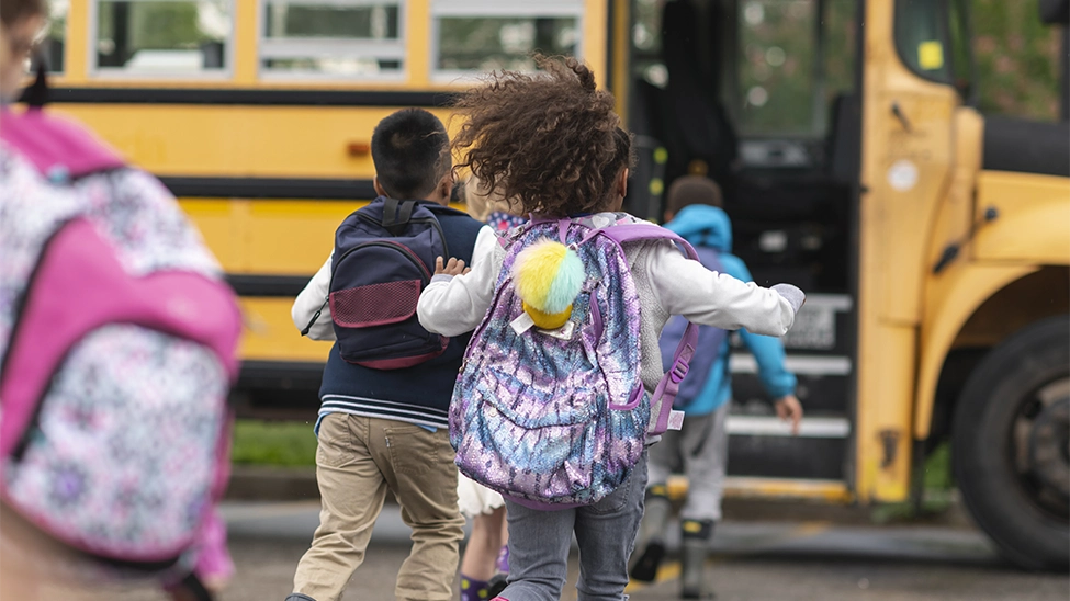 Kids running to a school bus