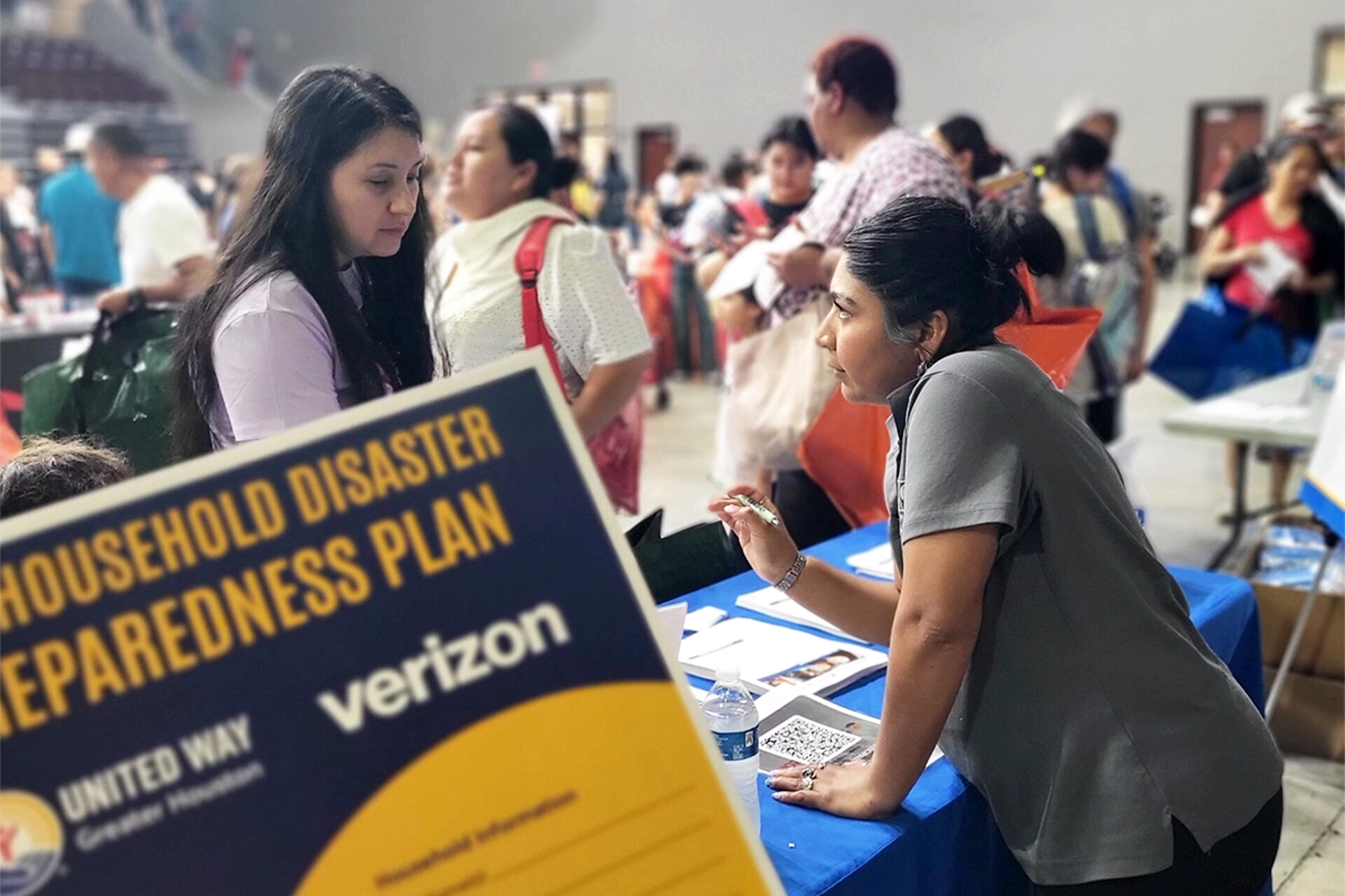 A woman stands at a table getting help while attending a United We Prepare Disaster preparation Workshop in Houston