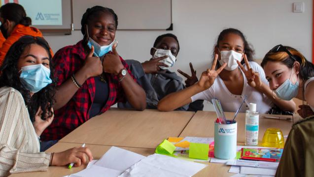 young people with face masks around table