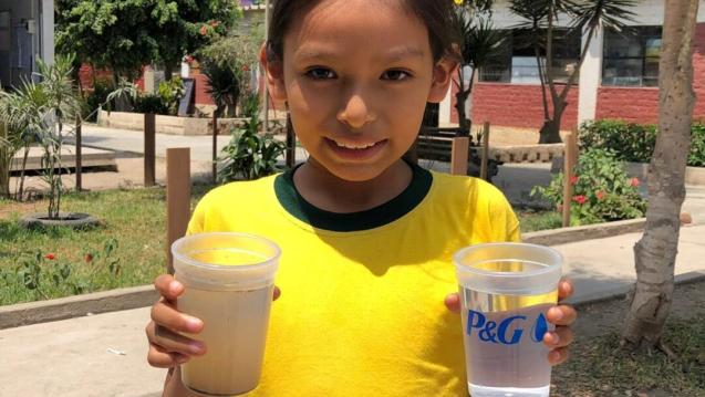 Young girl from Peru holding one cup of dirty water and one cup of clean water