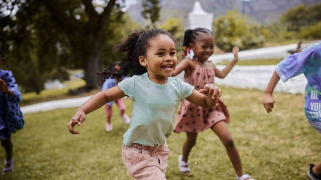 Children running in through grass