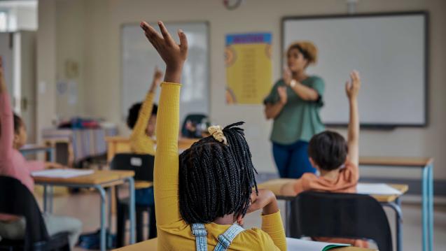 Children raising their hands in a classroom
