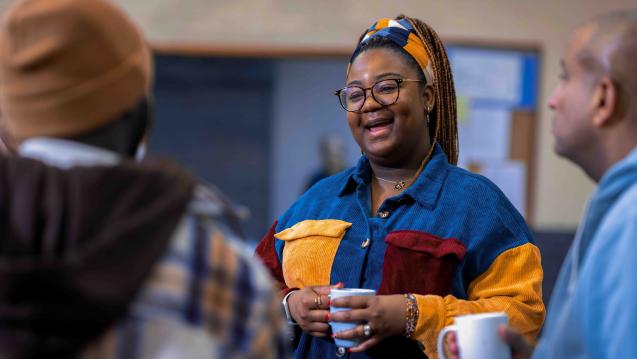 Woman holding a coffee mug in a small group