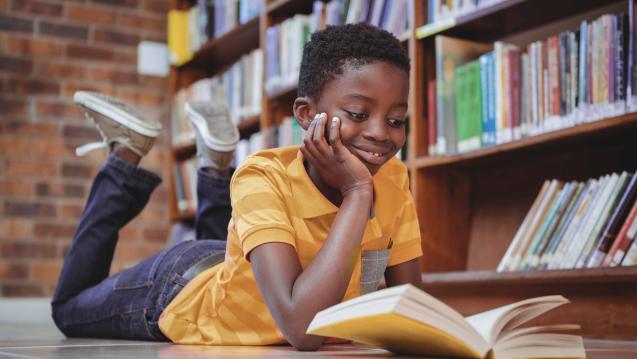 Boy reading a book in a library