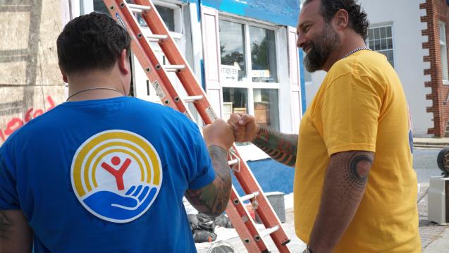 Two Men Working on a project together in United Way shirts