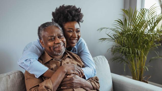 Grown women hugging her dad on the couch