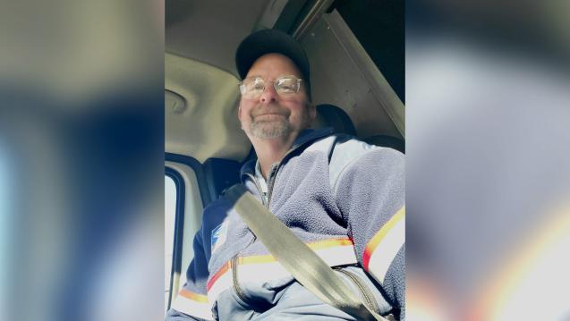 Letter carrier Russell smiling in his vehicle