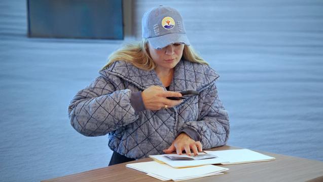 A woman using her phone to take a picture of a document