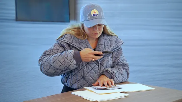 A woman using her phone to take a picture of a document