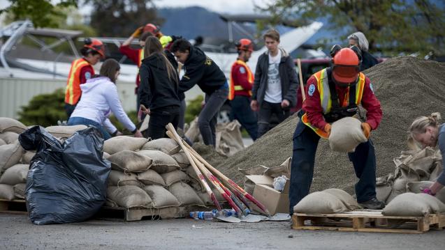 Workers stack sandbags to prevent flooding damage
