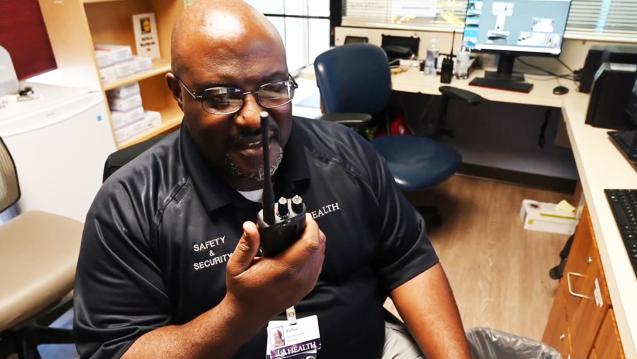 Hospital safety and security staffer talking into new radio