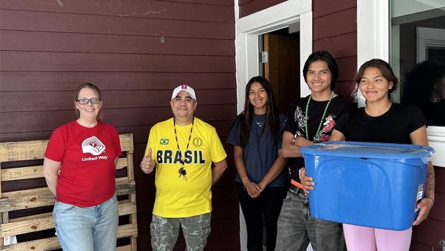 Volunteers holding food donations packed in boxes