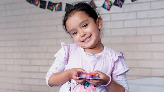 Emily, a five-year-old student at United Way Colombia's learning center in Bogotá's Bosa neighborhood, holding artworka 