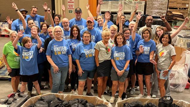 A group of 25 United Way Suncoast Volunteers standing and cheering 