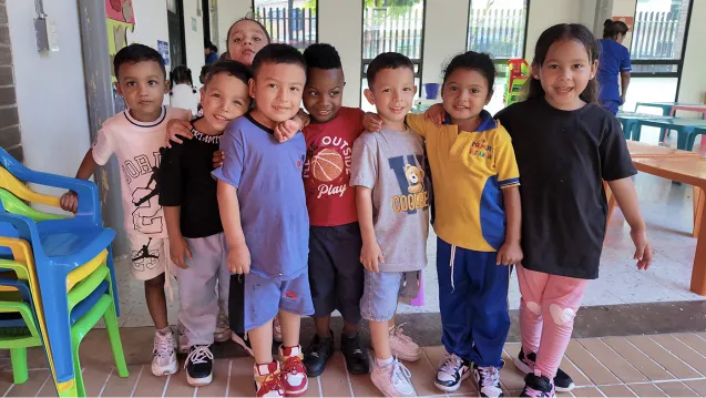 A group of young schoolchildren in Colombia standing together and smiling at the camera