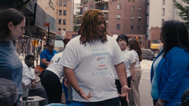 Resiliency Ambassador Sha-King Smith interacting with people at a block party.