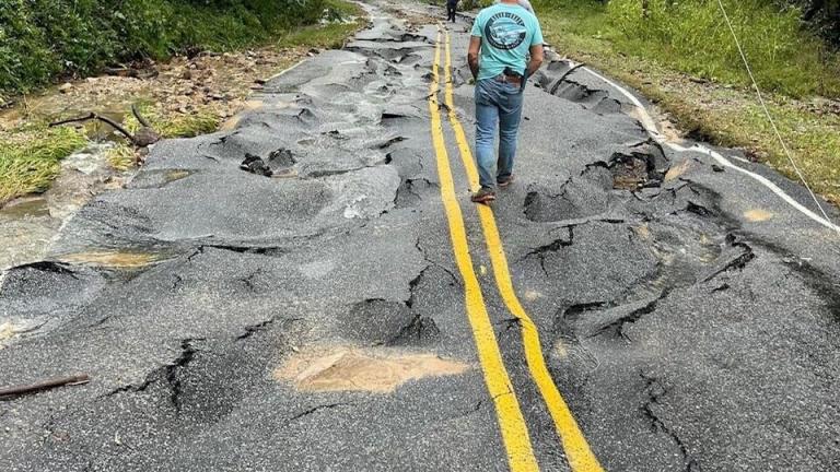 man walking on a broken road