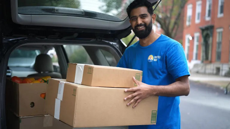 Man outside car with boxes