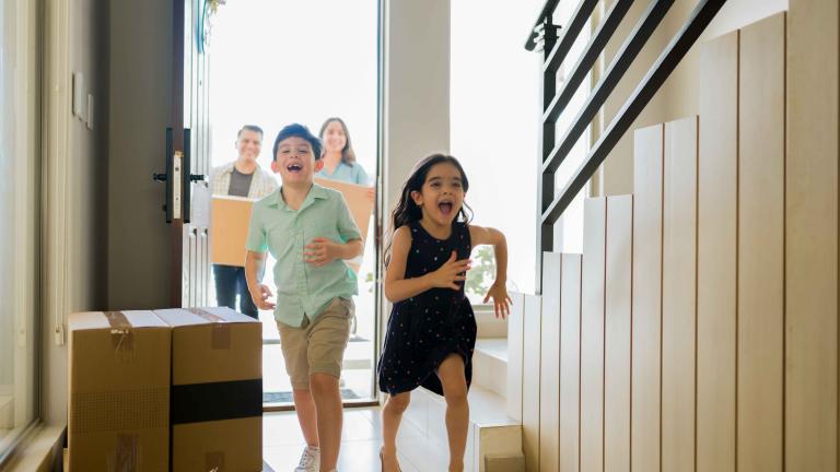Children running into a home through moving boxes