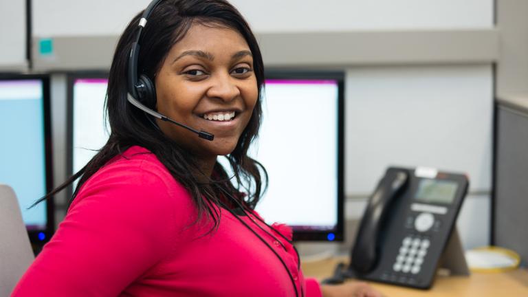 Woman in red shirt with headset on for 2-1-1