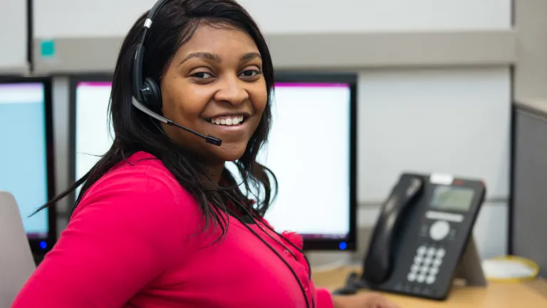Woman in red shirt with headset on for 2-1-1
