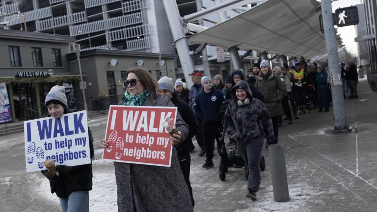 Group of individuals walking holding signs