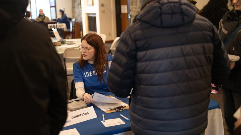 Woman working a check in table at community event