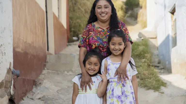 Woman standing outside with her two children