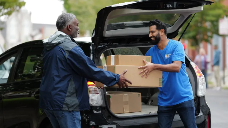 Man in United Way shirt collecting a donation of boxed goods