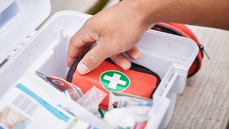 Hand reaching into first aid kit
