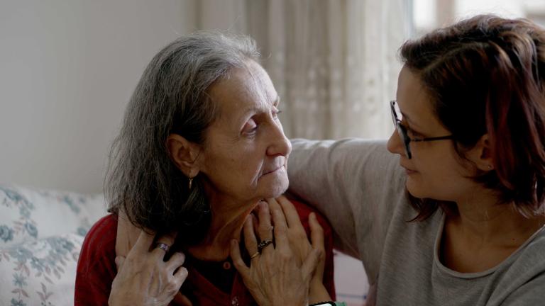 A woman with her arm around an elderly womn