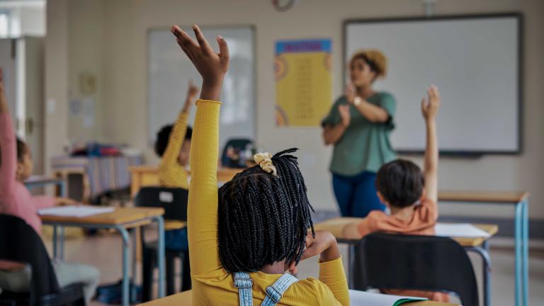 Children raising their hands in a classroom