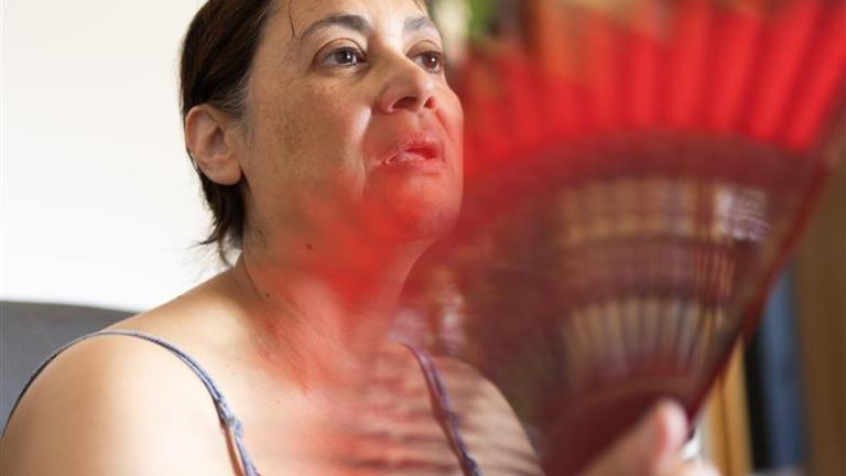 Woman who is fanning herself in hot weather