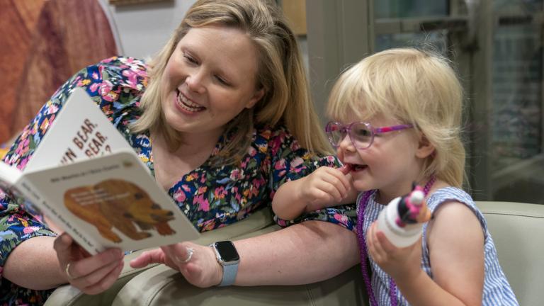 An adult reading to a child in Crosstown Learning Center