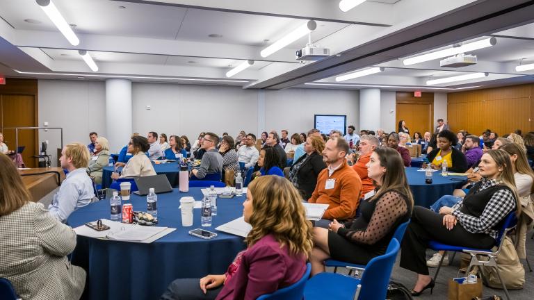 The audience of the MGLC seated around tables.