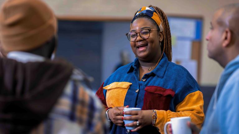 Woman holding a coffee mug in a small group