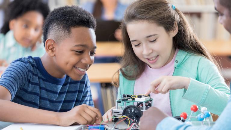 Two young students in science class working together