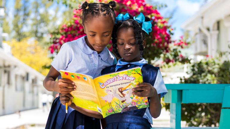 Two girls reading a book together