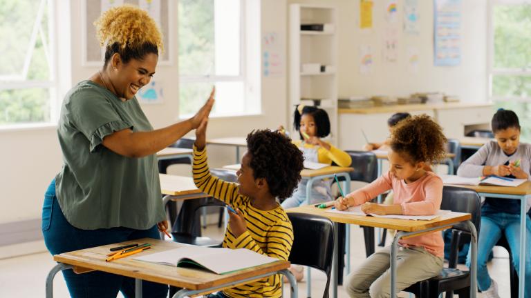 Teacher in a school giving a student a high five