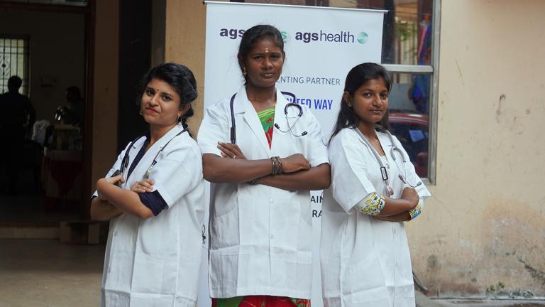 Three women wearing medical lab coats and stethoscopes. 