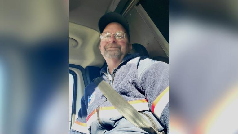 Letter carrier Russell smiling in his vehicle