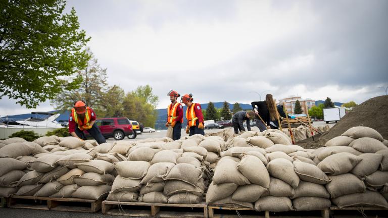 workers pile up sandbags to prepare for a flood