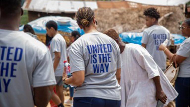 A person wearing a United is the Way T-shirt walking in Accra, Ghana 