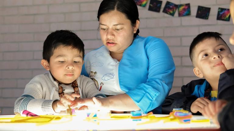 Teacher Yuileidy Tobar leads a classroom activity with students Erick and Andrés at Ojo de Perdiz Preschool, a learning center supported by United Way Colombia.