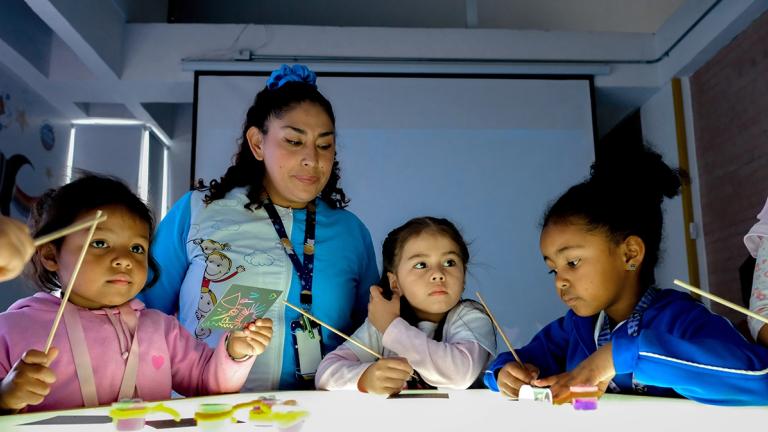 Teacher Ruth Cruz guides children during a hands-on learning activity in the experiential classroom at Ojo de Perdiz Preschool, supported by United Way Colombia